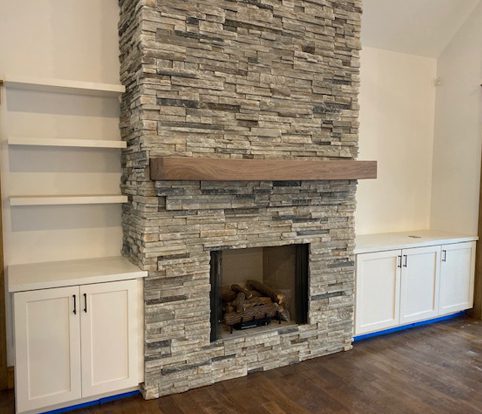 Rice Furniture & Design Center | custom wood mantle and cabinets surrounding brick fireplace