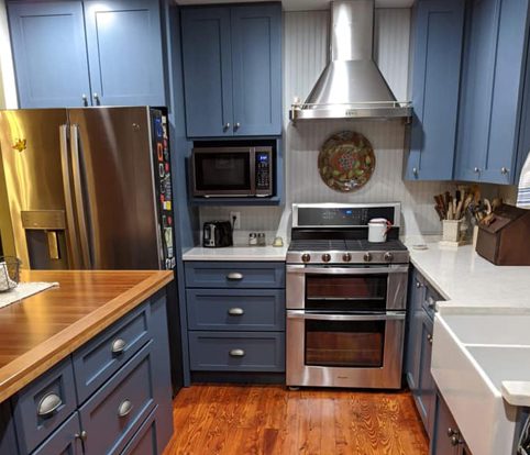 Rice Furniture & Design Center | Design Center custom built cabinets for a kitchen painted a dark blue with silver fixtures